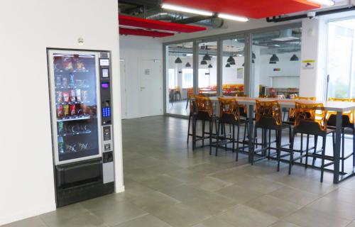 un restaurant avec une table et des chaises ainsi qu'un distributeur automatique dans l'établissement Appart-Hotel Mer & Golf City Ile de Nantes, à Nantes