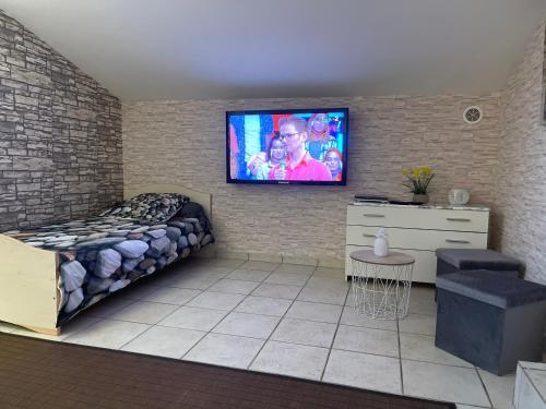 une chambre avec un lit et une télévision sur un mur de briques dans l'établissement Chez Chris Mare & Macchia, à Porto-Vecchio