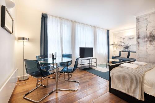 um quarto com uma mesa e cadeiras e uma cama em Oxford Street London by Threstle em Londres