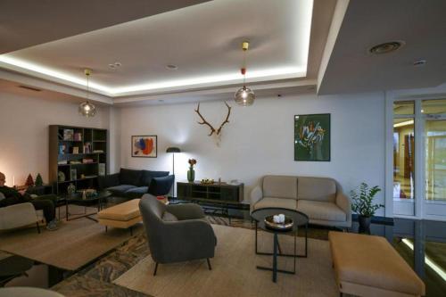 a living room with couches and chairs and a table at NOVAK apartman in Vrnjačka Banja