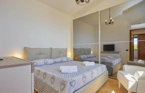 ein Schlafzimmer mit 2 Betten und ein Wohnzimmer in der Unterkunft Villa dei Mori in Scopello