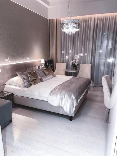 een slaapkamer met een groot bed en een kroonluchter bij Dune B Mielno Exclusive in Mielno