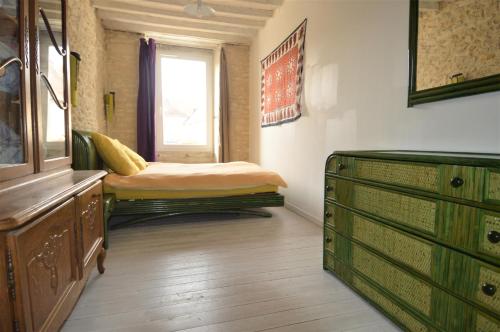 a bedroom with a bed and a dresser and a window at Maison de charme bord de mer - Avec jardin et wifi in Luc-sur-Mer
