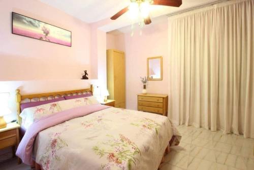 1 dormitorio con 1 cama, vestidor y ventana en Excelente apartamento vacacional en Guardamar a unos pasos de la playa, calle Paraguay en Guardamar del Segura