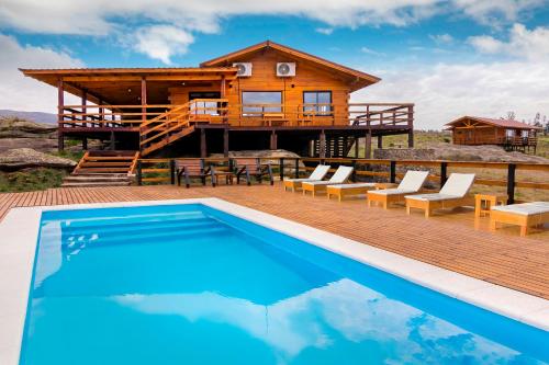 eine Blockhütte mit einem Pool und einem Haus in der Unterkunft Alma Serrana - Suites de montaña! in La Cumbrecita