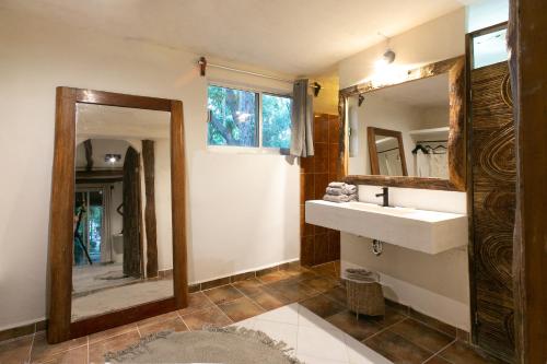 a bathroom with a sink, toilet, and bathtub at Amansala Chica Resort in Tulum