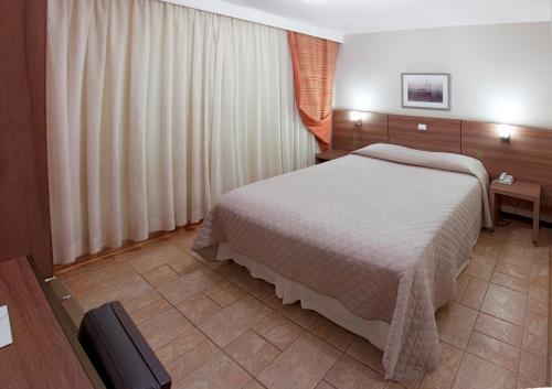 a bedroom with a large bed in a room at PARANÁ PALACE HOTEL in Campo Mourão