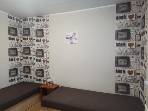 - une chambre avec un lit et un mur avec des photos dans l'établissement Apartmán Tatranská Lomnica, à Tatranská Lomnica