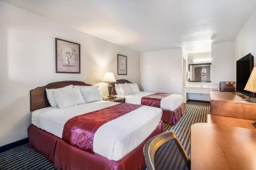 a hotel room with two beds and a desk at Americas Best Value Inn New Braunfels in New Braunfels