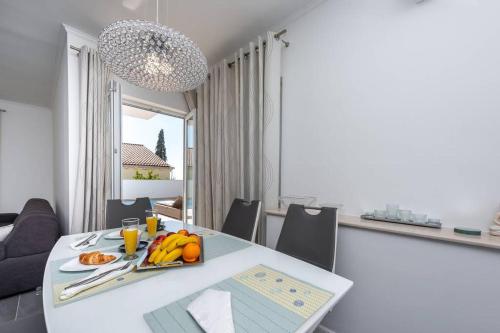 a dining room with a table with fruit on it at Deluxe Apartment Unique-With Private Heated Pool in Cavtat