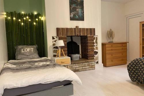 a bedroom with a bed and a fireplace at Une pause aux Halles. Maison de ville pour 5 pers max in Pontgouin