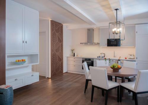a kitchen with white cabinets and a table and chairs at BalaLake Resort in Szántód
