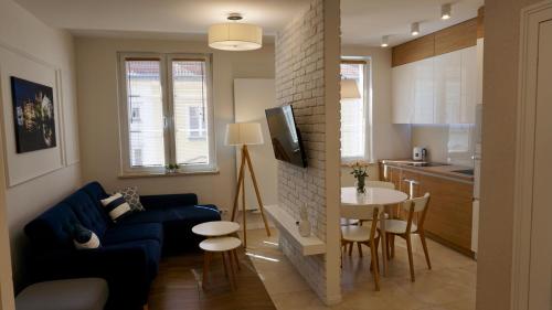 a living room with a blue couch and a kitchen at Apartament w samym sercu Opola in Opole