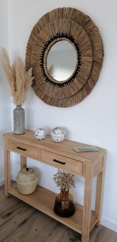 un miroir sur un mur au-dessus d'une table en bois dans l'établissement capplouneour, à Plounéour-Trez