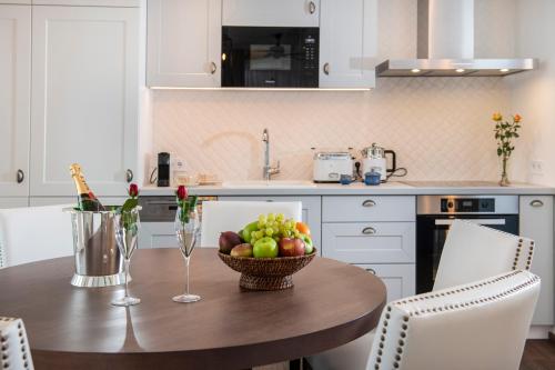 a kitchen with a wooden table with a bowl of fruit at BalaLake Resort in Szántód