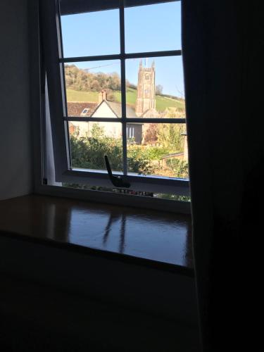 a window in a room with a view of a church at New for 2021 Welcome to Violet Cottage in Combe Martin