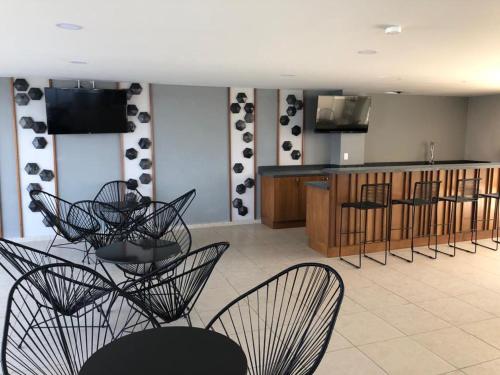 a room with chairs and a table and a kitchen at Departamento de lujo en el Malecón in Mazatlán