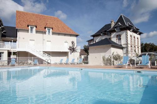 une grande piscine en face d'un bâtiment dans l'établissement Résidence Odalys Le Domaine des Dunettes, à Cabourg