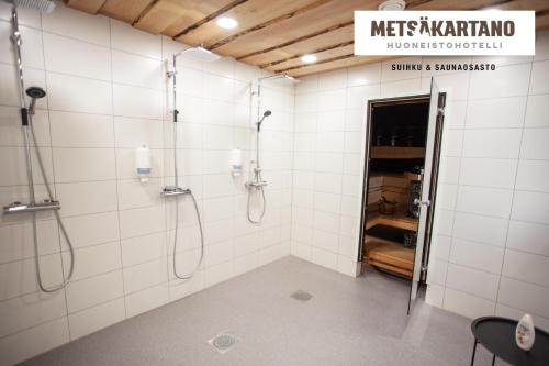 a bathroom with a shower with white tiles at Metsäkartano in Kannus