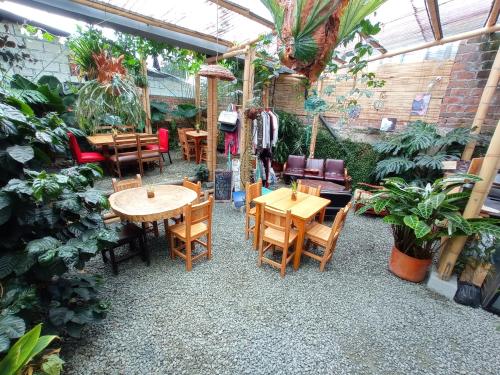 un restaurante con mesas, sillas y plantas en Bidea Backpackers Hostel, en Filandia