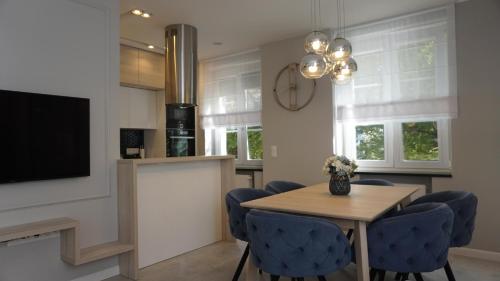 uma sala de jantar com uma mesa e cadeiras azuis em Apartament w samym sercu Opola 2 em Opole