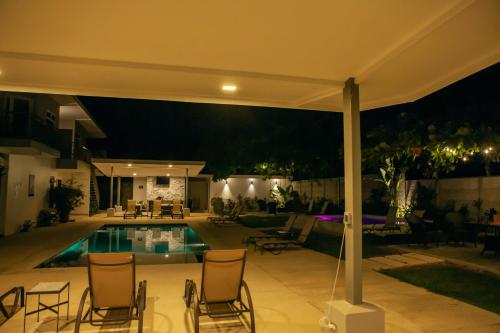 a swimming pool at night with chairs around it at Uvita Paradise in Uvita