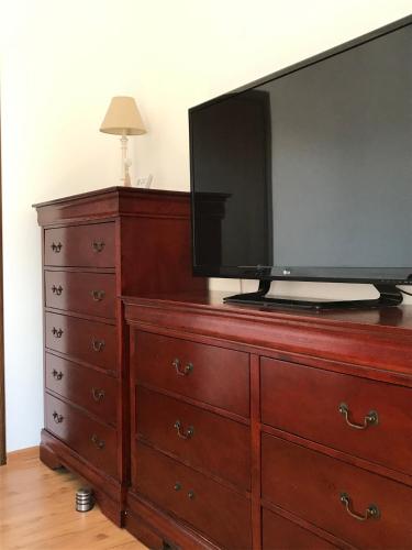 a dresser with a flat screen tv on top of it at Orange Onix Apartaments in Bucharest