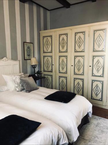 a bedroom with a large white bed with striped walls at Il Pioppo Antico in Viggiù