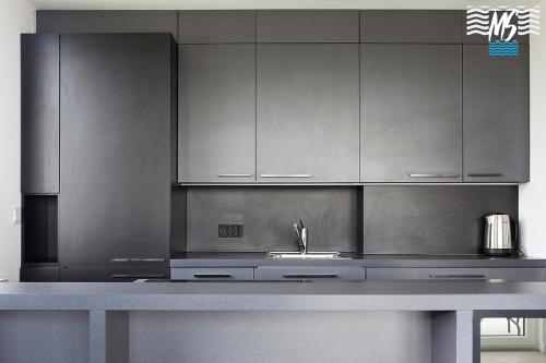 a kitchen with stainless steel cabinets and a sink at MS Apartments Green Hill II in Gdynia