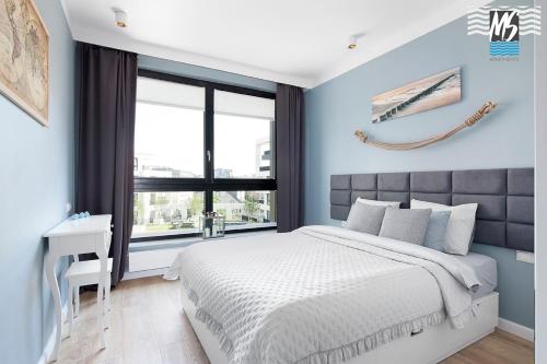 Un dormitorio con una cama grande y una ventana en MS Apartments Matros, en Gdynia