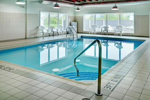 a swimming pool with a pool table and chairs at Coastal Inn Halifax - Bayers Lake in Halifax