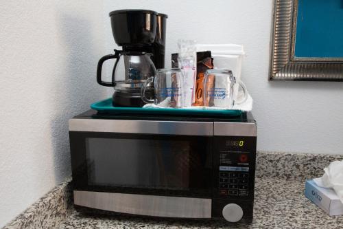 a microwave with a coffee pot on top of it at Daytona Dream Inn By AmeriVu in Daytona Beach
