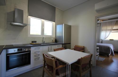 a kitchen with a table and a kitchen with a dining room at Lida Garden Loft in Anavissos