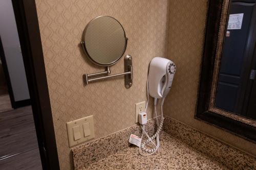 a hair dryer on a bathroom counter with a mirror at The Azure Hotel in Mesa