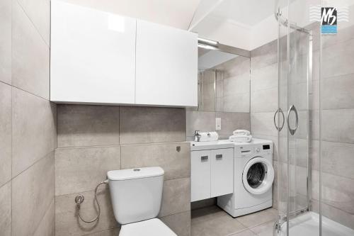 La salle de bains est pourvue de toilettes et d'un lave-linge. dans l'établissement MS Apartments Antica, à Gdynia