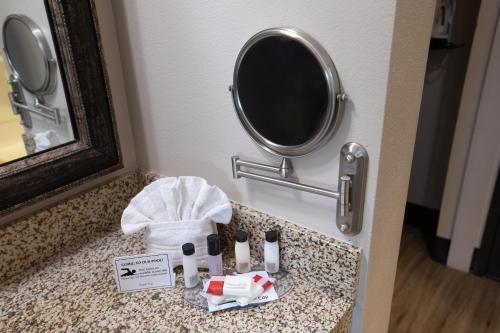 a bathroom counter with a mirror and a sink at The Azure Hotel in Mesa