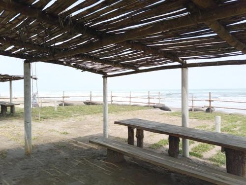 a wooden bench sitting under a pavilion at the beach at Hotel La Estrella Polar in Costa Esmeralda