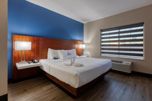 a bedroom with a large bed with a blue wall at The Azure Hotel in Mesa