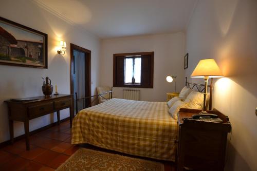 a bedroom with a bed and a table with a lamp at Quinta De Cima De Eiriz in Guimarães