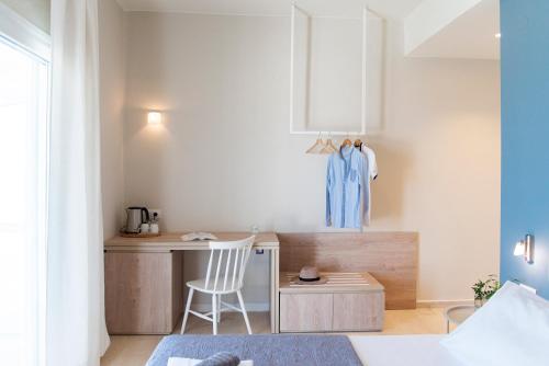 Cette chambre comprend une petite cuisine avec un bureau et une chaise. dans l'établissement Ammos Apartments, à Kavos