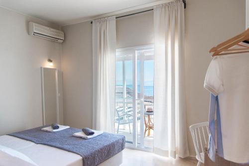 a bedroom with a bed and a view of the ocean at Ammos Apartments in Kavos