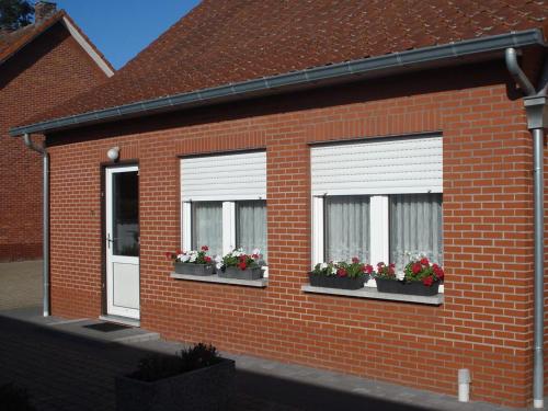 a brick house with three windows with flower boxes at Serene Holiday Home in Peer in Peer