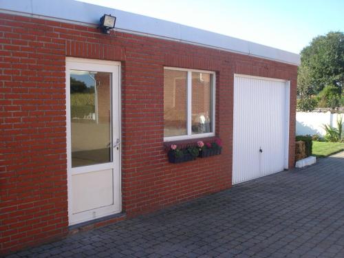 a red brick building with a white door and a window at Serene Holiday Home in Peer in Peer