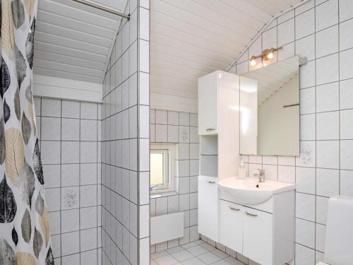 ein weißes Badezimmer mit einem Waschbecken und einem Spiegel in der Unterkunft Holiday home Humble XXVIII in Humble