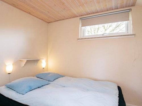 a bedroom with a bed with two pillows and a window at Seaside Charm in Ristinge-By Traum in Humble