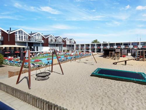 een strand met schommels en een zwembad en een resort bij 6 person holiday home on a holiday park in Glesborg in Glesborg