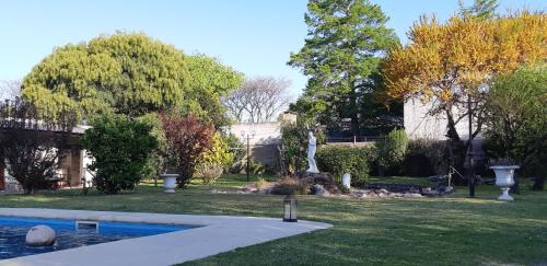 a yard with a swimming pool and trees and a house at Mykonos Carmelo in Carmelo