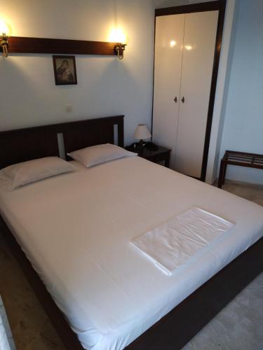 a large white bed in a room with a door at Daskalio Beach Hotel in Keratea
