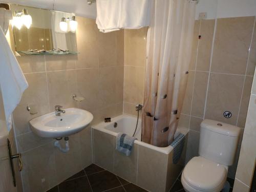 a bathroom with a sink and a toilet and a shower at Daskalio Beach Hotel in Keratea