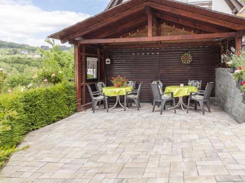 a patio with a yellow table and chairs on it at Gemütliches Appartement in Hallenberg mit Terrasse in Hallenberg